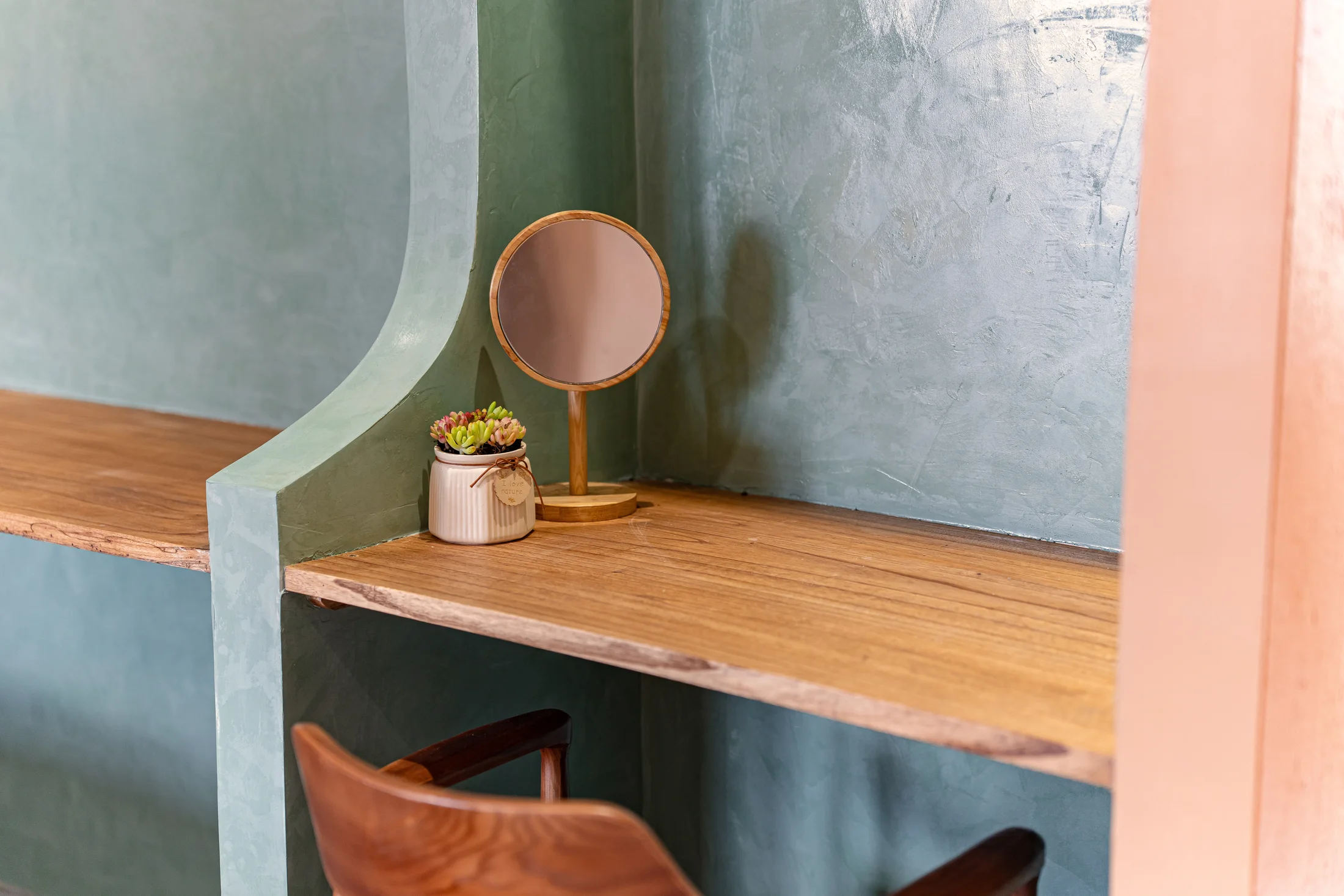 Curved sage wall and timber dressing table